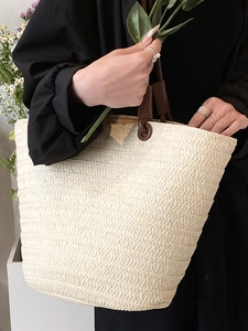 French straw tote bag with brown leather handles and woven texture for summer