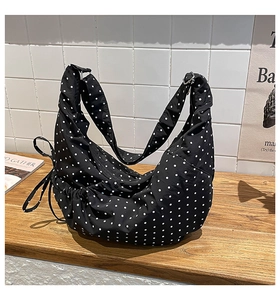 Detailed view of the black and white polka dot hobo bag with adjustable strap and side drawstrings