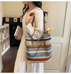 Détail du grand sac cabas tissé à rayures colorées avec des anses en cuir marron élégant