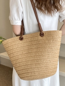 French straw tote bag with brown leather straps for summer beach or daily commute