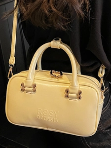 Minimalist beige PU leather Boston bag with gold heart-shaped zippers for elegant commuting