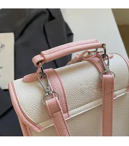 Detail shot of pink and white textured leather handbag with silver metal buckles
