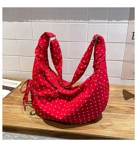 Detail of red polka dot canvas hobo bag with soft drawstring pleats and wide strap