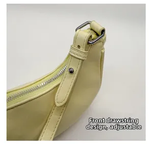Detailansicht der gelben Tasche mit silbernem Reißverschluss und verstellbarem Riemen