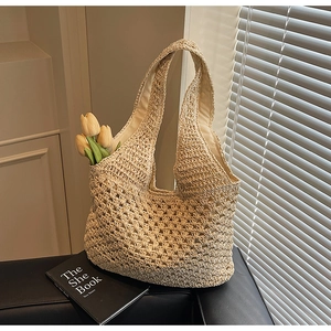 Detail of hollow woven pattern on beige straw tote bag with inner fabric lining