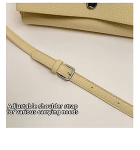 Detail of adjustable shoulder strap with silver metal buckle on lychee leather bag