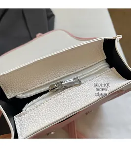 Detail view of pink and white lychee leather handbag showing smooth silver zipper puller