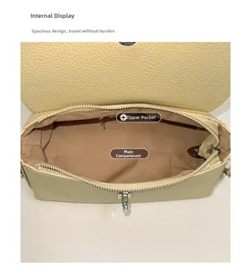 Interior detail of yellow lychee grain leather handbag with main compartment and zip pocket