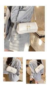 Detail showing creamy white leather baguette bag with a golden metal buckle and shoulder strap