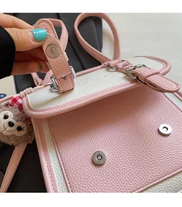 Close-up of pink and white pebbled leather bag with secure magnetic buckle closure