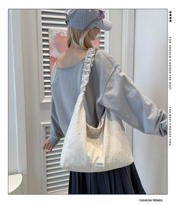 Detail view of the star print canvas tote bag with unique ruffled cloud shoulder straps