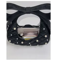 Top view of quilted bow handbag interior showing capacity for phone and cosmetics