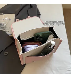 Detail of pink and white crossbody bag interior showing spacious compartments and storage