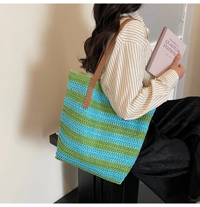 Detail of colorful woven tote bag with rainbow stripes and premium brown leather handles