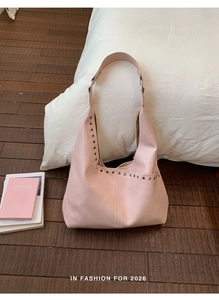 Detailansicht der rosa Hobo-Tasche mit Metallösen und breitem Schultergurt aus Leder