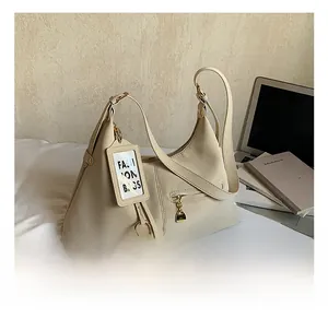 Détails du sac hobo beige montrant la texture du cuir et les boucles dorées