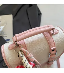 Detailed close-up of premium lychee texture leather and pink stitched handle of a bucket bag