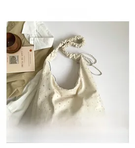 Detail of cream canvas tote bag with silver star prints and pleated shoulder strap