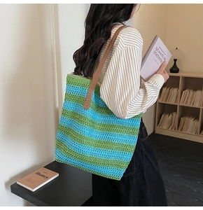 Détail du sac cabas tissé à rayures bleues et vertes avec anses en cuir marron chic