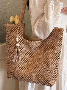 Lazy straw tote bag with woven hollow texture and tassel detail for summer vacations