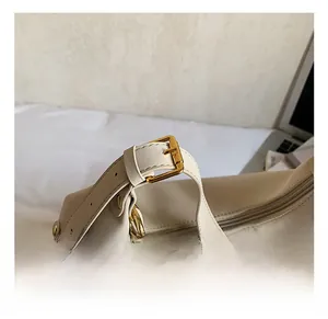 Détail du sac cabas beige avec bandoulière réglable dorée et étiquette de mode chic