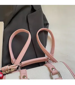 Detail showing high-quality lychee texture leather and pink shoulder strap of the square bag