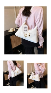 Détail du sac sous le bras blanc en forme de croissant avec cadenas doré et breloque