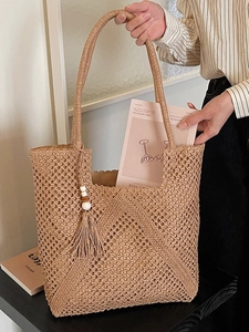 Handwoven straw tote bag with fringe tassels and mesh pattern for summer beach vacations