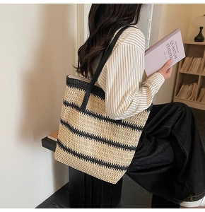 Detailed texture of striped woven beach tote with black shoulder straps in a cozy setting