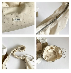Detail of canvas tote bag featuring silver star patterns and ruched cloud shoulder strap