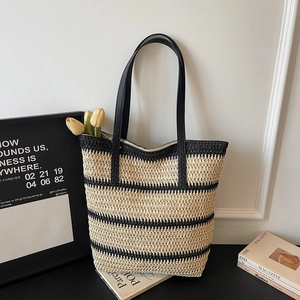 Détail du sac cabas tissé à rayures avec bandoulières en cuir noir et fermeture éclair