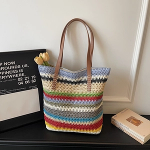 Gros plan du sac cabas tissé à rayures colorées avec ses anses en cuir marron et coutures