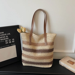 Détail du sac cabas tissé dégradé avec anses en cuir marron et accent floral