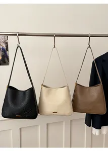 Trois sacs seaux en cuir noir, beige et marron avec détail de texture craquelée vintage