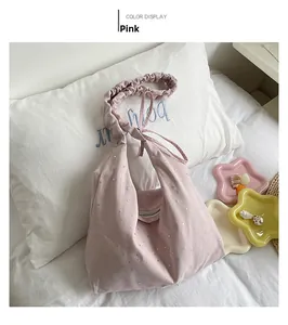 Detail shot of pink canvas tote bag featuring silver stars and ruffled shoulder strap detail