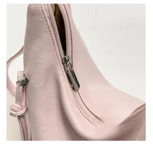 Detail of silver metal zipper and hardware on pink leather commuter tote bag