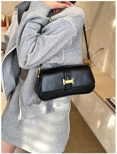 Close-up of elegant black leather shoulder bag featuring a signature gold H-clasp