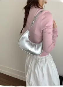 Detailansicht der metallisch silbernen Halbmond Schultertasche mit Fashion Logo