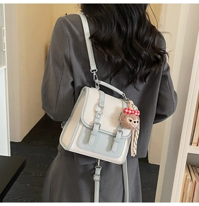 Detail of the white and light blue crossbody bag with plush charm and荔枝纹理 leather