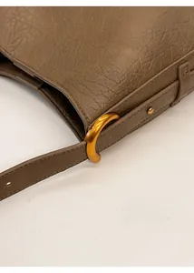 Gros plan sur le cuir texturé du sac fourre-tout avec boucle dorée réglable