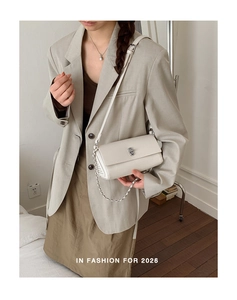 White lychee leather shoulder bag with silver turn-lock and chain strap on a model