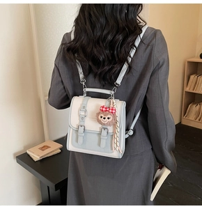 Detail of a chic two-tone crossbody bag featuring a ShellieMay plush charm and buckle