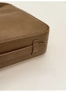 Vue détaillée des coutures et de la base du sac seau en cuir marron foncé