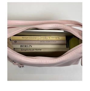 Spacious interior of light pink PU leather tote bag holding a laptop and several books