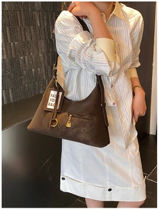 Gros plan du sac sous le bras marron foncé avec texture grainée et fermeture dorée