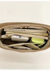 Vue intérieure du sac seau en cuir marron montrant sa grande capacité et ses compartiments