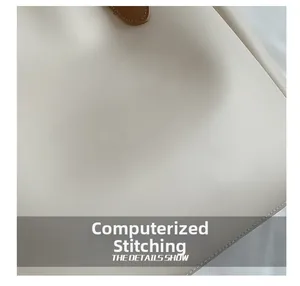 Close-up of precise computerized stitching on premium beige leather tote bag detail