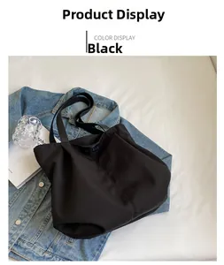 Close-up of black nylon tote bag featuring embossed logo detail with stylish urban props