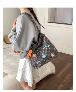 Dettaglio della borsa tote in tweed grigio con motivo a quadri e ciondolo a cavallo