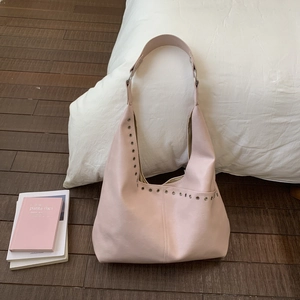 Detailansicht der rosa Ledertasche mit silbernen Nieten und breitem Schultergurt